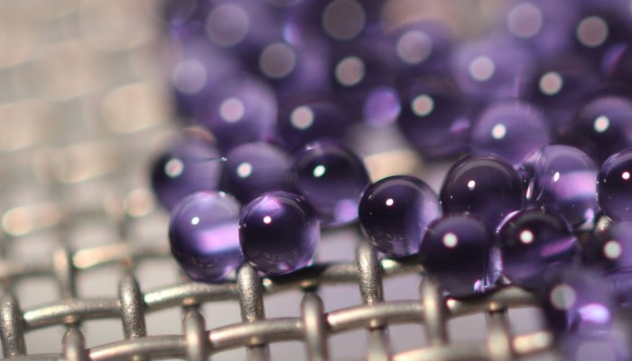 Microcapsules containing sodium carbonate solution are suspended on a mesh during carbon dioxide absorption testing. The mesh allows many capsules to be tested at one time while keeping them separated, exposing more of their surface area. Credit: John Vericella, Lawrence Livermore National Laboratory.